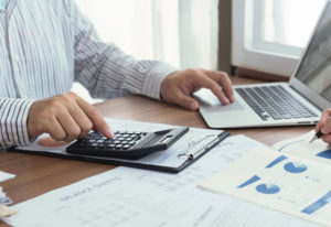 Accountant at computer also working with a calculator