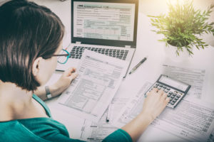 Woman in green dress doing taxes at a computer