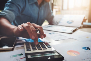 Business accounting concept, Business man using calculator with computer laptop, budget and loan paper in office.